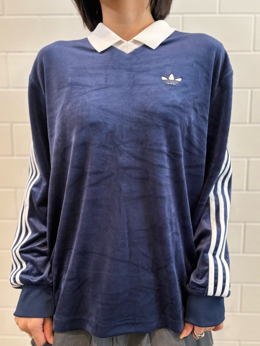 ブラウン系のショルダーバッグ、ベージュ系のスニーカー、ブルー系のポロシャツを着用したレディースの春コーディネートの4枚目の写真