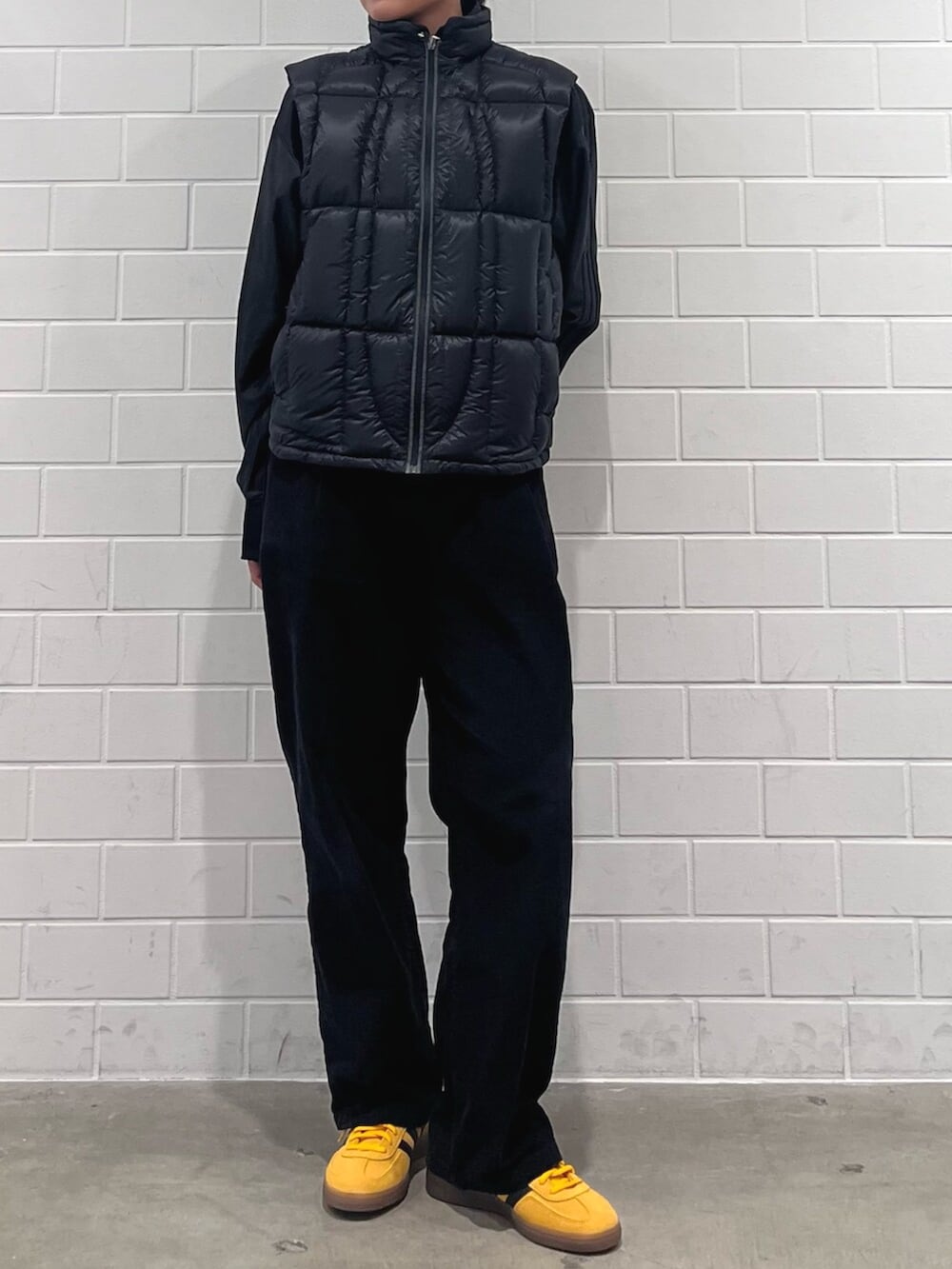 ブラック系のジャケット/アウター、イエロー系のスニーカー、ブラック系のジャージを着用したレディースの冬コーディネートの2枚目の写真