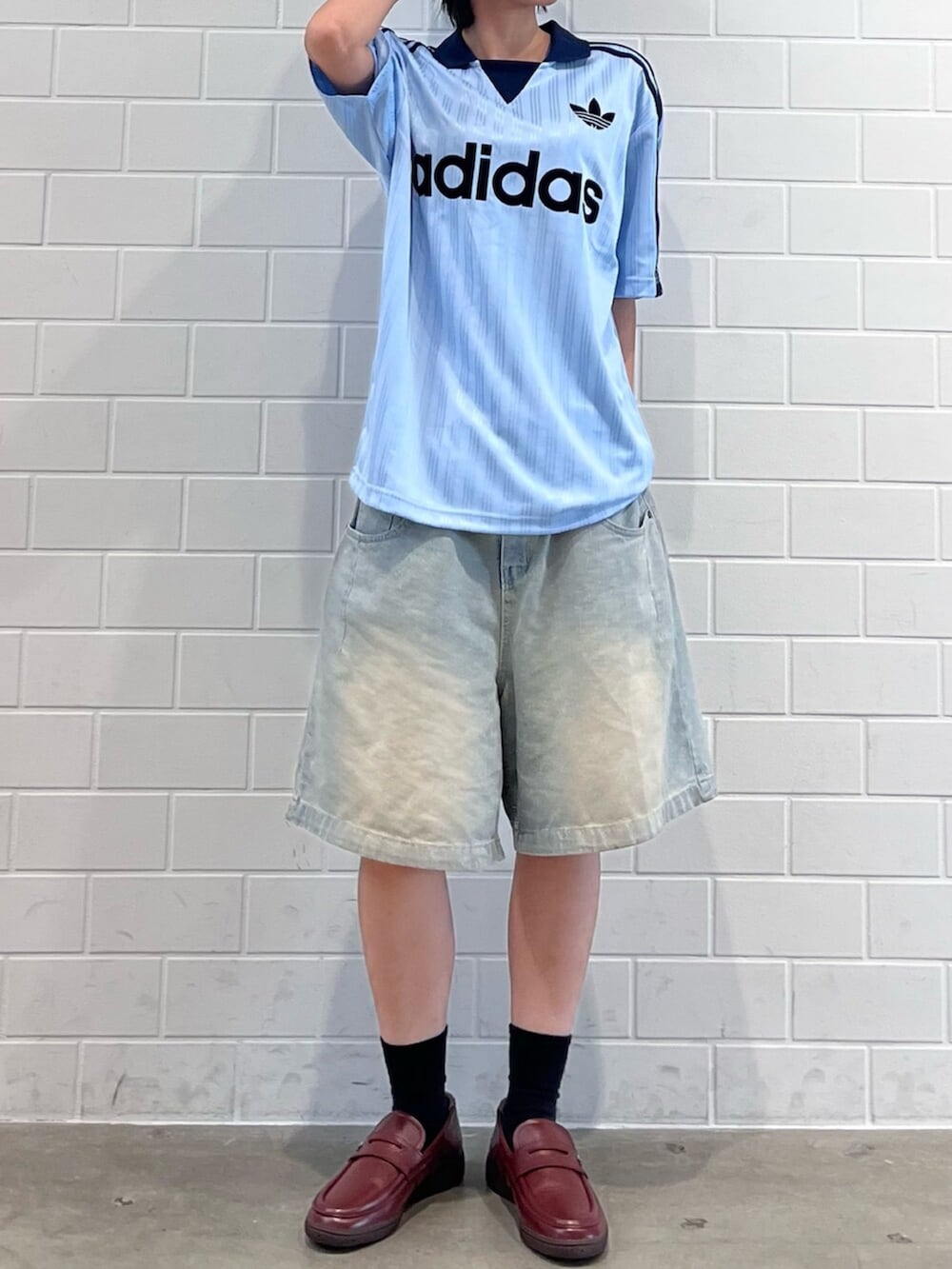 ブラウン系のローファー、ブルー系のTシャツ/カットソー、ブラック系のアクセサリーを着用したレディースの夏コーディネートの2枚目の写真