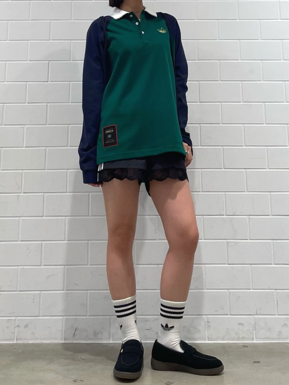 ブラック系のエコバッグ/サブバッグ、ブラック系のその他パンツ、グリーン系のポロシャツを着用したレディースの冬コーディネートの2枚目の写真