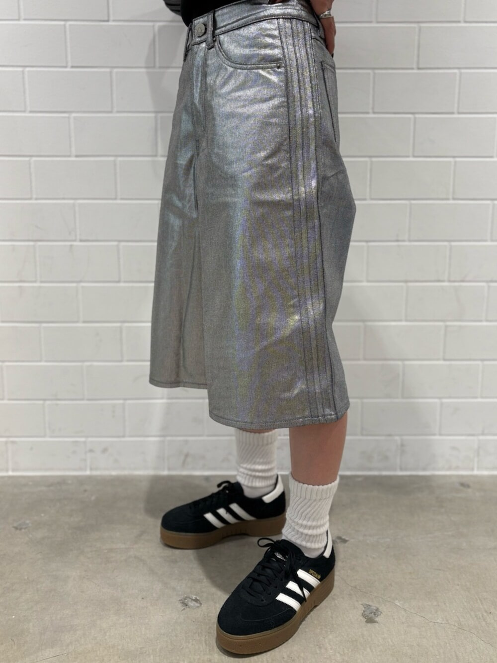 ブラック系のデニムジャケット、ブラック系のスニーカー、シルバー系のデニムパンツを着用したレディースの冬コーディネートの5枚目の写真