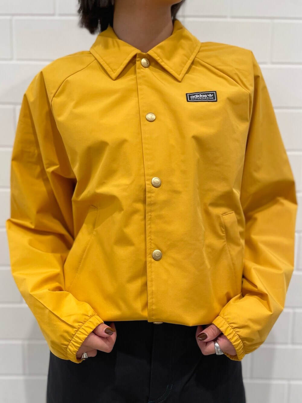 イエロー系のブルゾン、ブラック系のその他パンツ、ブラック系のスニーカーを着用したレディースの冬コーディネートの4枚目の写真