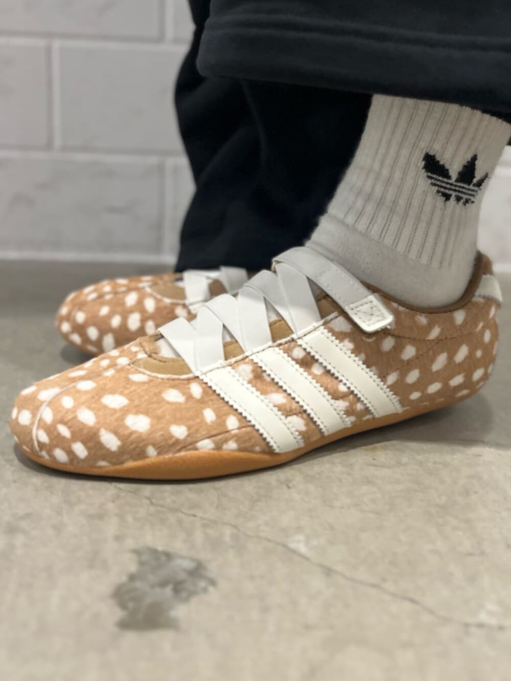 ブラック系のその他パンツ、ブラウン系のスニーカー、ベージュ系のハンドバッグを着用したレディースの秋コーディネートの6枚目の写真