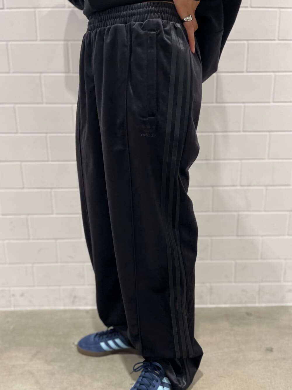 ブラック系のスウェットパンツ、ブルー系のスニーカー、ブラック系のトップスを着用したレディースの秋コーディネートの5枚目の写真