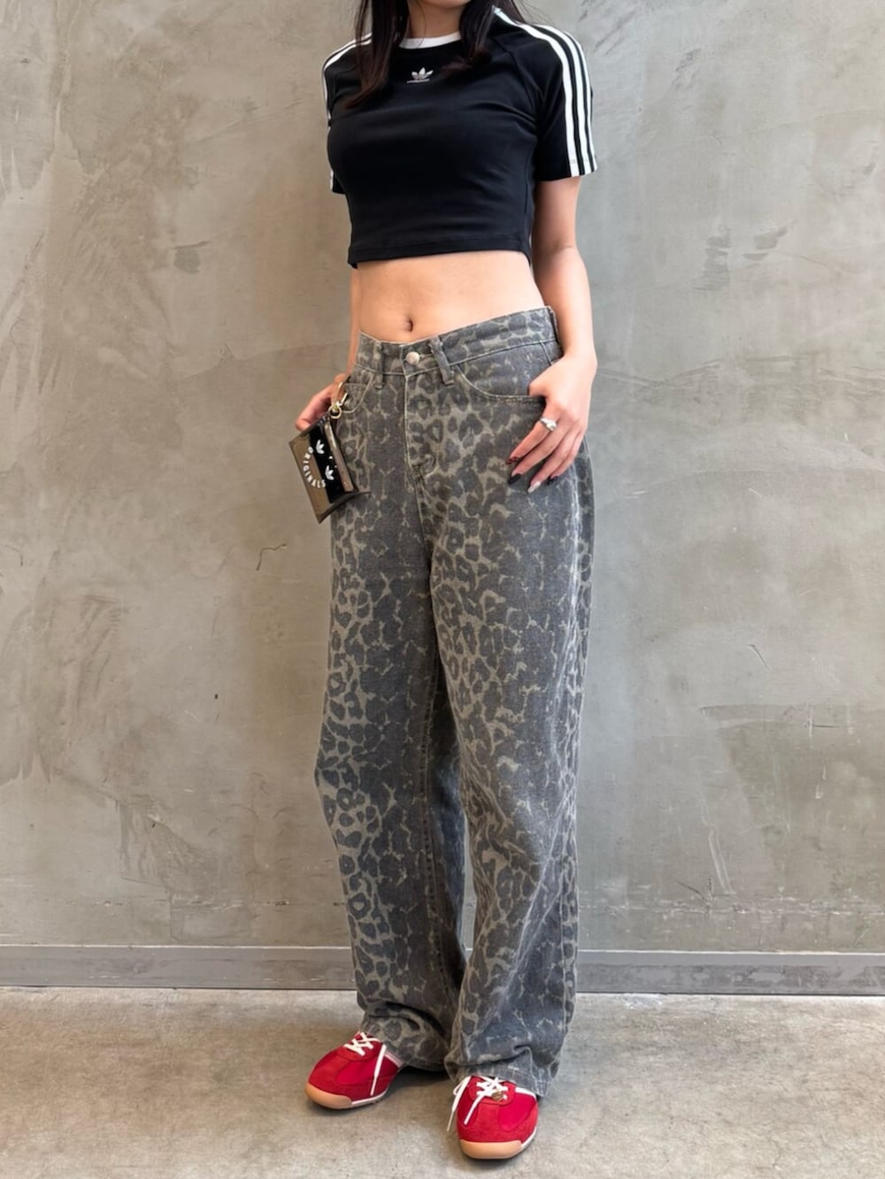 ブラック系のシューズアクセサリー、ブラック系のTシャツ/カットソー、レッド系のスニーカーを着用したレディースの夏コーディネートの2枚目の写真