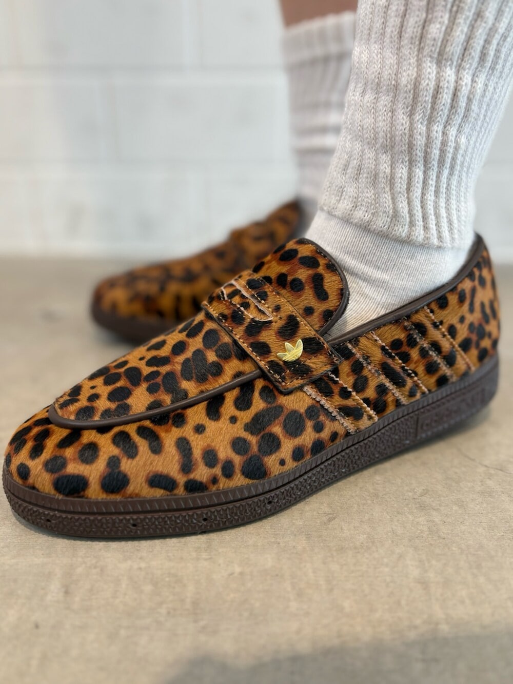 ブラウン系のショルダーバッグ、ベージュ系のスニーカー、ブルー系のポロシャツを着用したレディースの春コーディネートの6枚目の写真