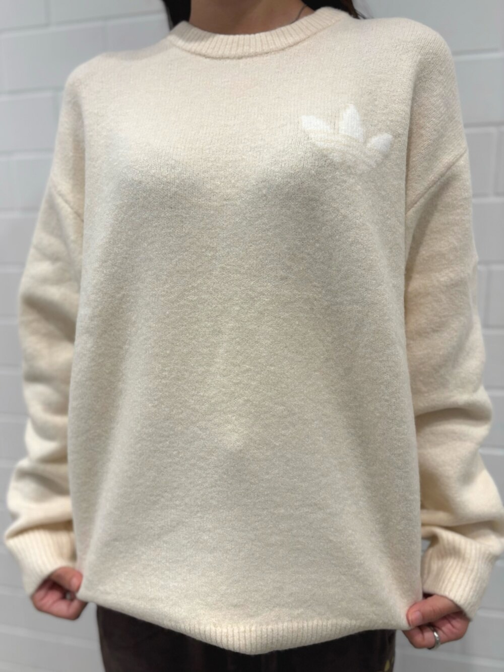 ブラウン系のパンツ、ホワイト系のニット/セーター、ベージュ系のショルダーバッグを着用したレディースの秋コーディネートの3枚目の写真