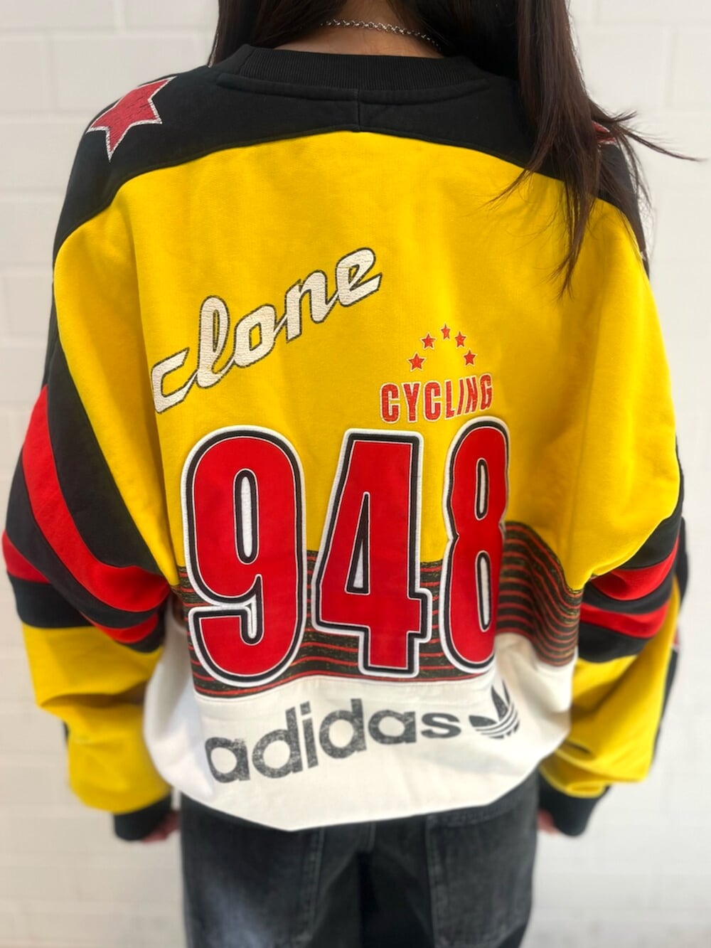 ブラック系のデニムパンツ、イエロー系のスウェット、レッド系のスニーカーを着用したレディースの秋コーディネートの4枚目の写真