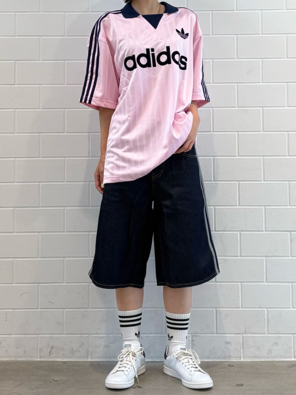 ブルー系のデニムパンツ、ピンク系のTシャツ/カットソー、ホワイト系のスニーカーを着用したレディースの夏コーディネートの2枚目の写真