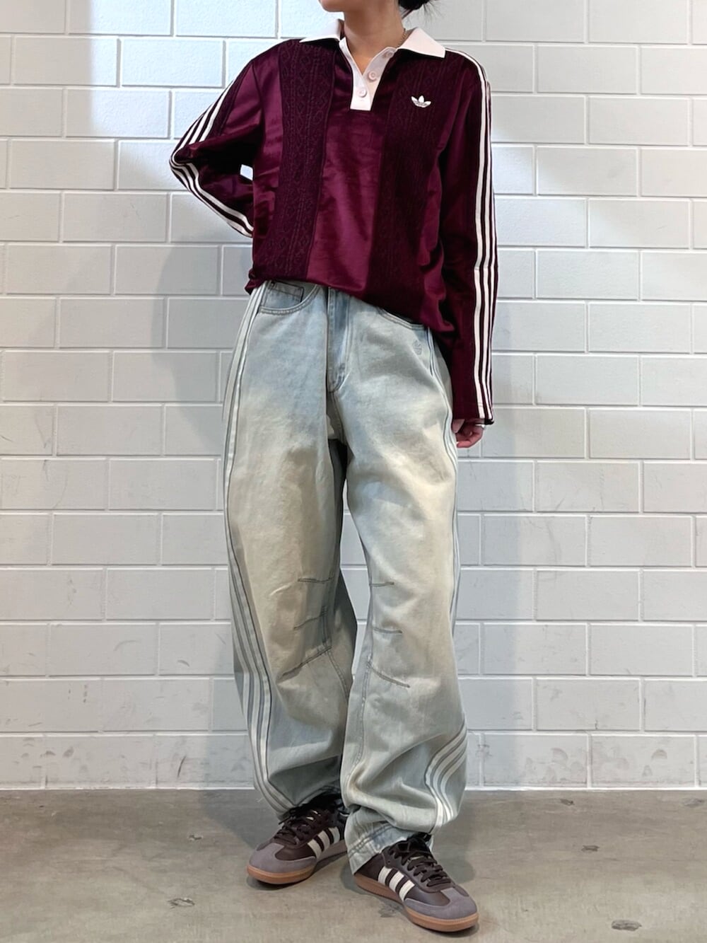 ブラウン系のスニーカー、ブルー系のデニムパンツ、レッド系のTシャツ/カットソーを着用したレディースの秋コーディネートの2枚目の写真