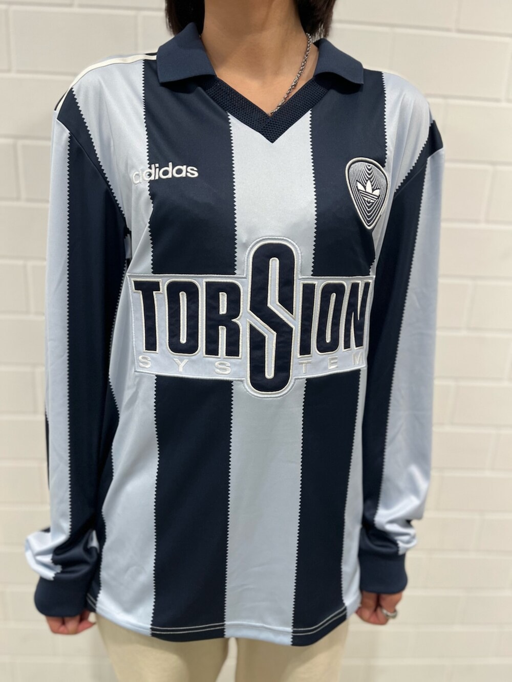 ブルー系のトップス、ブラック系のスニーカーを着用したレディースの冬コーディネートの4枚目の写真