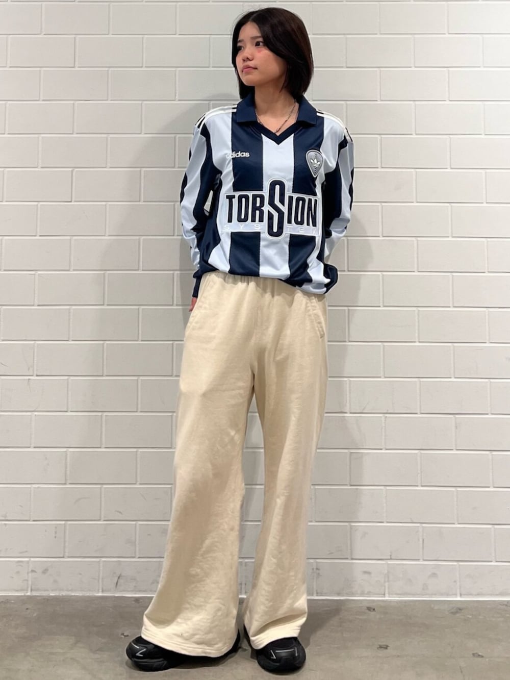 ブルー系のトップス、ブラック系のスニーカーを着用したレディースの冬コーディネートの3枚目の写真