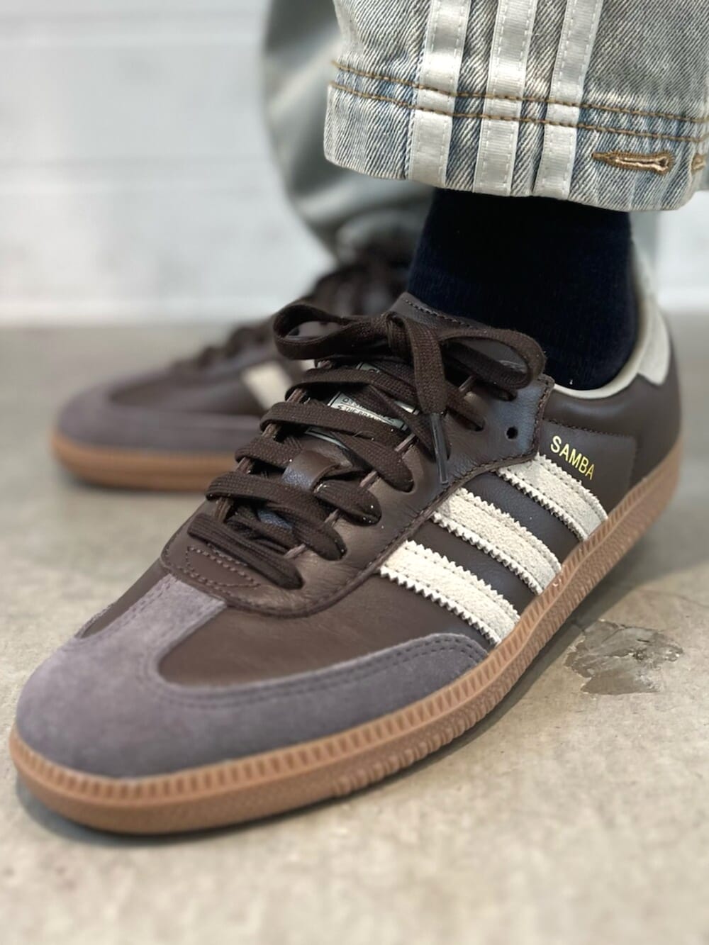 ブラウン系のスニーカー、ブルー系のデニムパンツ、レッド系のTシャツ/カットソーを着用したレディースの秋コーディネートの6枚目の写真