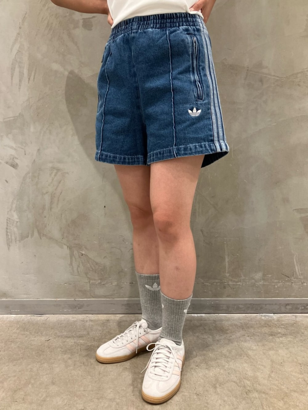 グレー系のスニーカー、ブルー系のデニムパンツ、ホワイト系のTシャツ/カットソーを着用したレディースの夏コーディネートの5枚目の写真