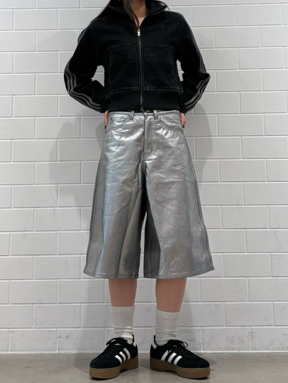 ブラック系のデニムジャケット、ブラック系のスニーカー、シルバー系のデニムパンツを着用したレディースの冬コーディネートの2枚目の写真