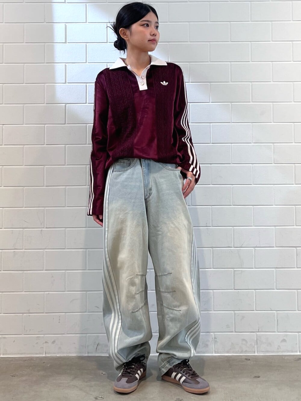 ブラウン系のスニーカー、ブルー系のデニムパンツ、レッド系のTシャツ/カットソーを着用したレディースの秋コーディネートの3枚目の写真