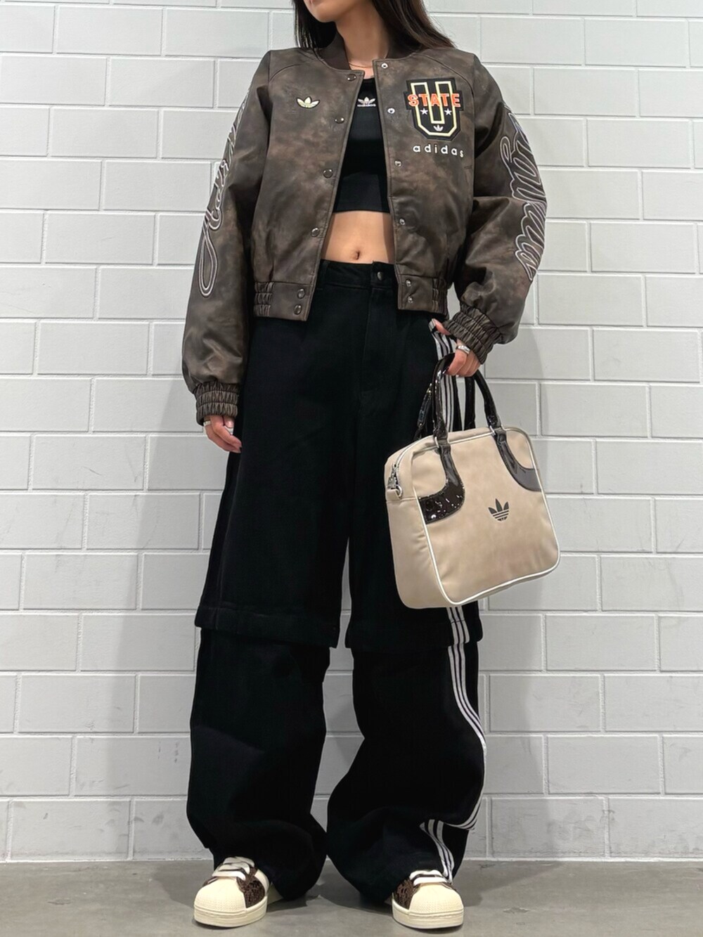 ベージュ系のショルダーバッグ、ブラウン系のジャケット/アウター、ブラック系のTシャツ/カットソーを着用したレディースの秋コーディネートの2枚目の写真