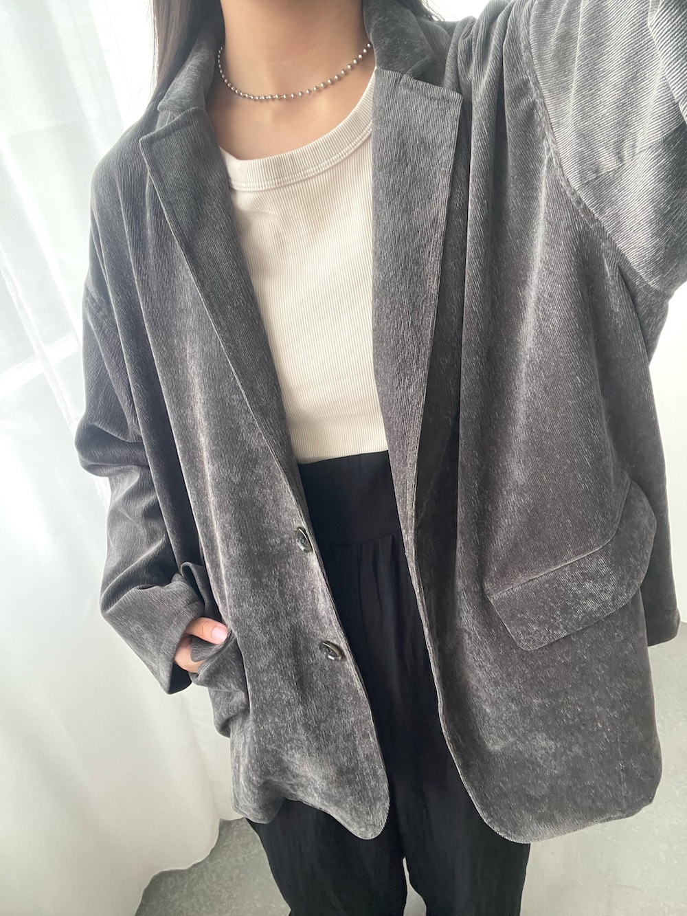 ブラック系のその他パンツ、ブラック系のテーラードジャケット、ホワイト系のタンクトップを着用したレディースの夏コーディネートの3枚目の写真