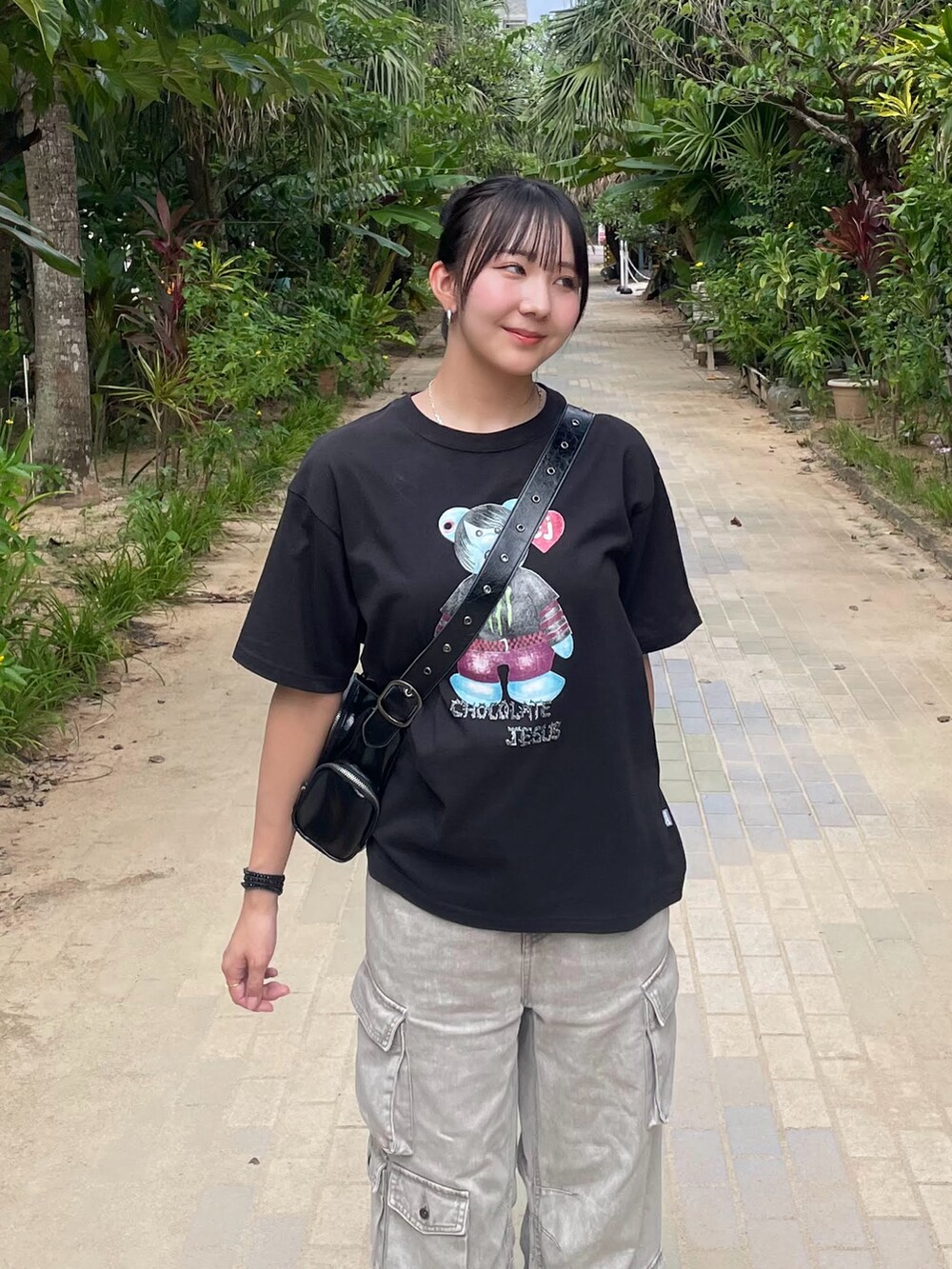 ブラック系のTシャツ/カットソー、ブラック系のショルダーバッグ、グレー系のデニムパンツを着用したレディースの夏コーディネートの2枚目の写真