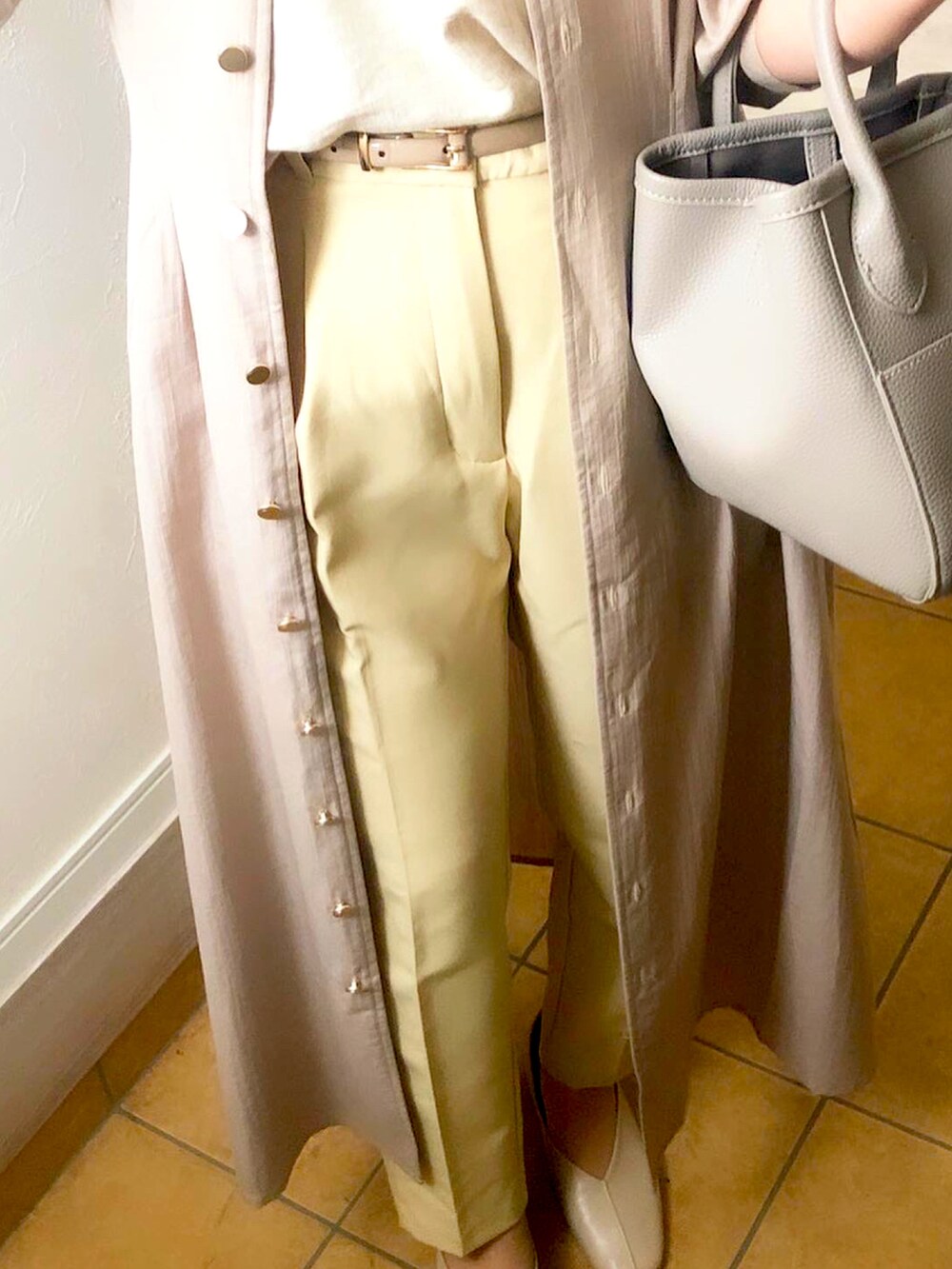 ベージュ系のシャツワンピース、ホワイト系のパンプス、イエロー系のパンツを着用したレディースの春コーディネートの2枚目の写真