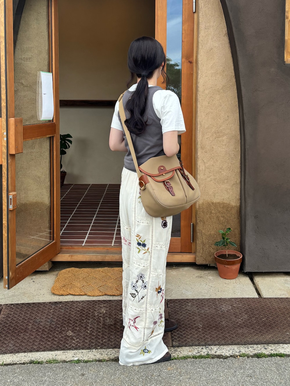 ホワイト系のその他パンツ、グリーン系のショルダーバッグを着用したレディースの春コーディネートの2枚目の写真
