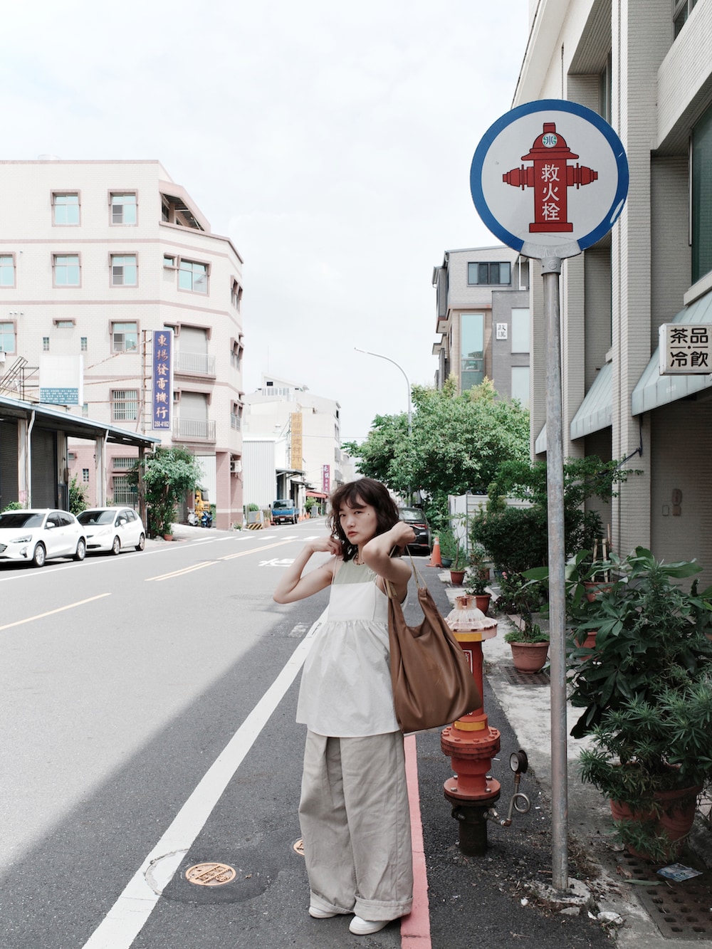 ベージュ系のデニムパンツ、ホワイト系のキャミソール、ブラウン系のトートバッグを着用したレディースの秋コーディネートの3枚目の写真