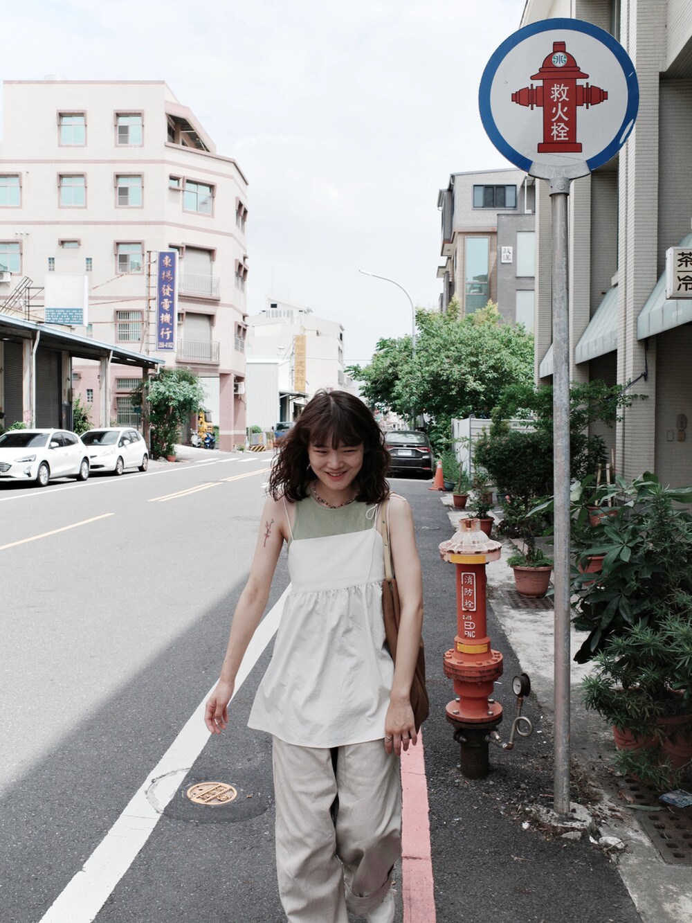 ベージュ系のデニムパンツ、ホワイト系のキャミソール、ブラウン系のトートバッグを着用したレディースの秋コーディネートの4枚目の写真