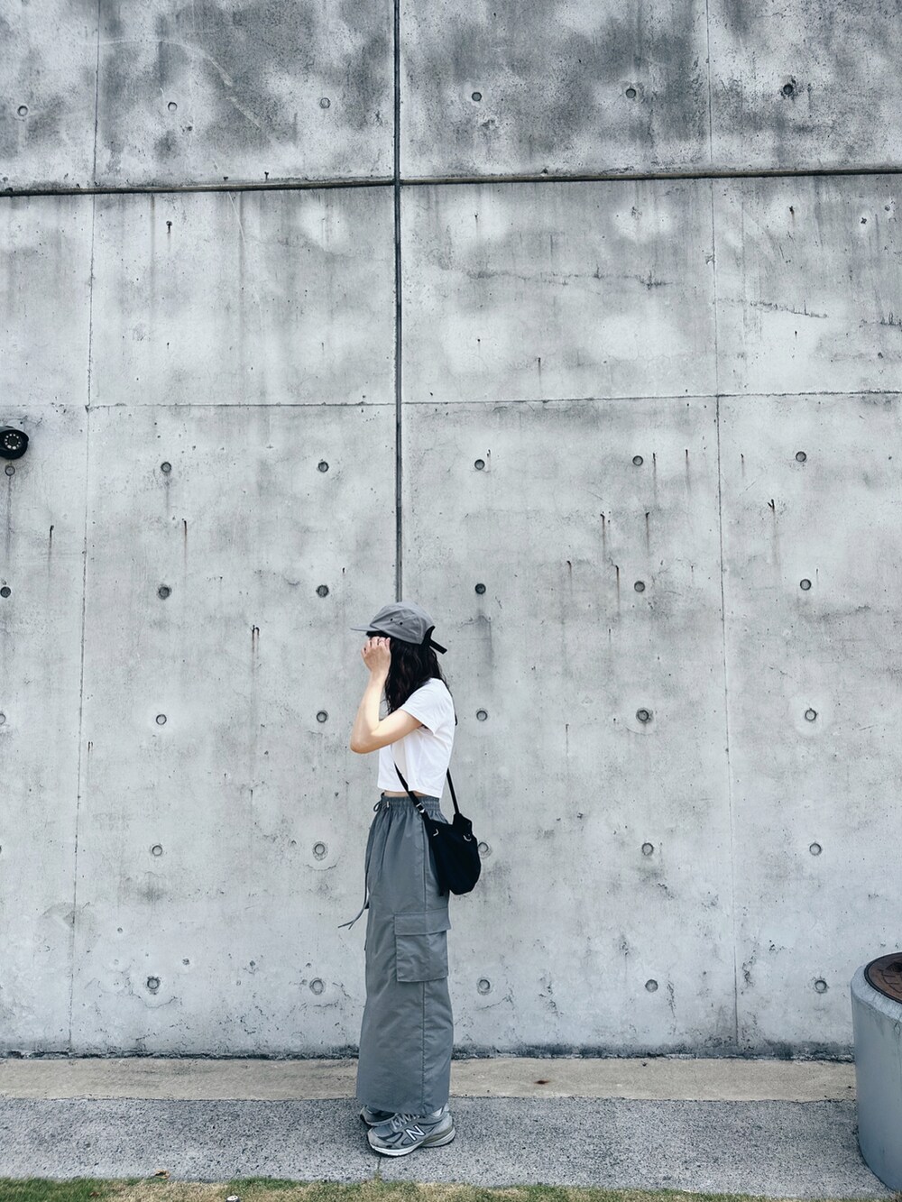 グレー系のスニーカー、ブラック系のショルダーバッグを着用したレディースの夏コーディネートの2枚目の写真