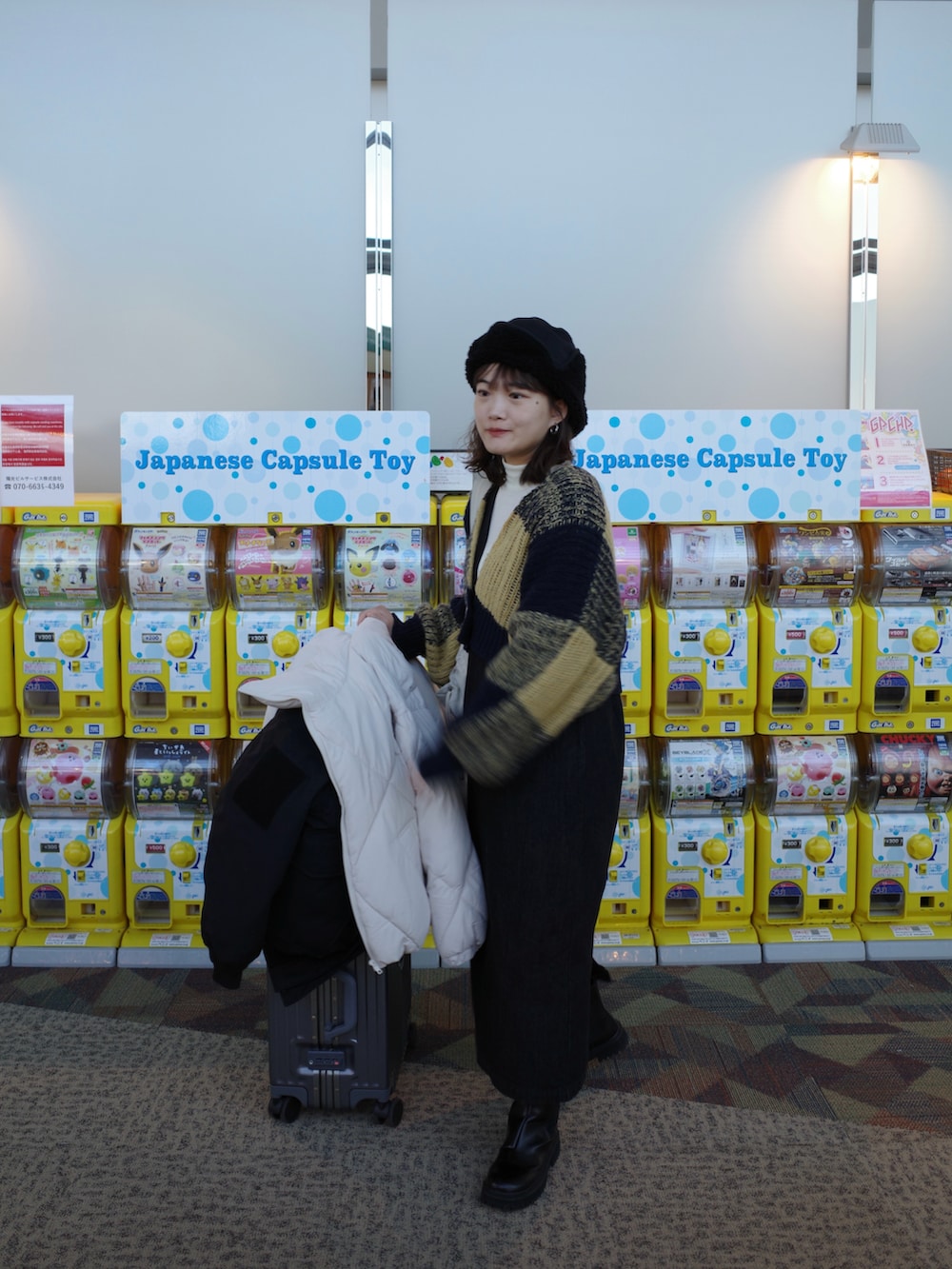 ブルー系のニット/セーター、ブラック系のジャンパースカート、ブラック系のブーツを着用したレディースの冬コーディネートの3枚目の写真