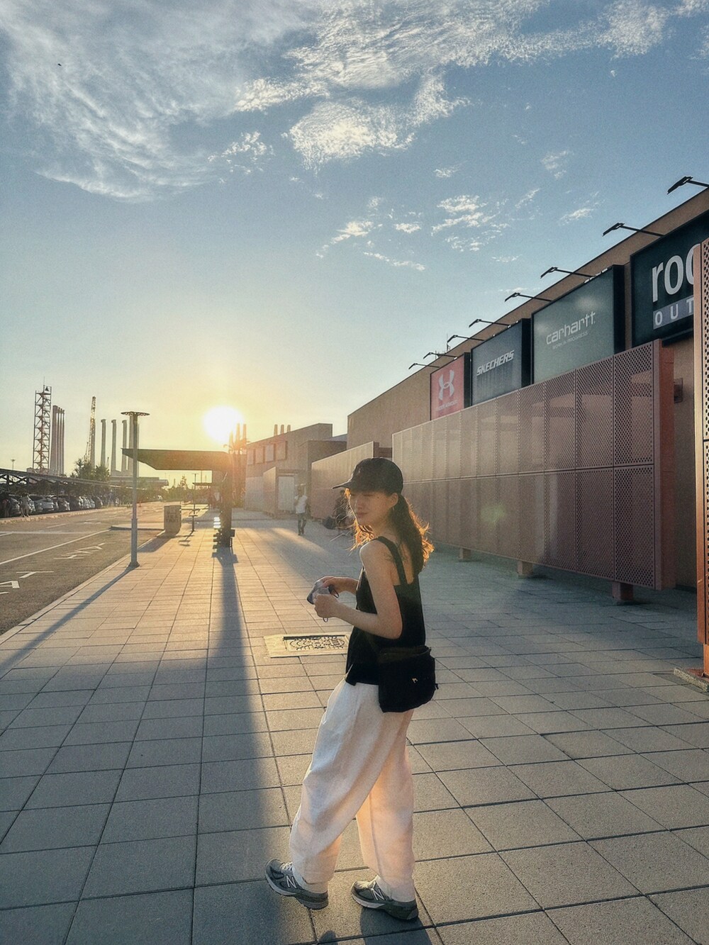 グリーン系のショルダーバッグ、グレー系のスニーカー、ブルー系のキャップを着用したレディースの夏コーディネートの2枚目の写真