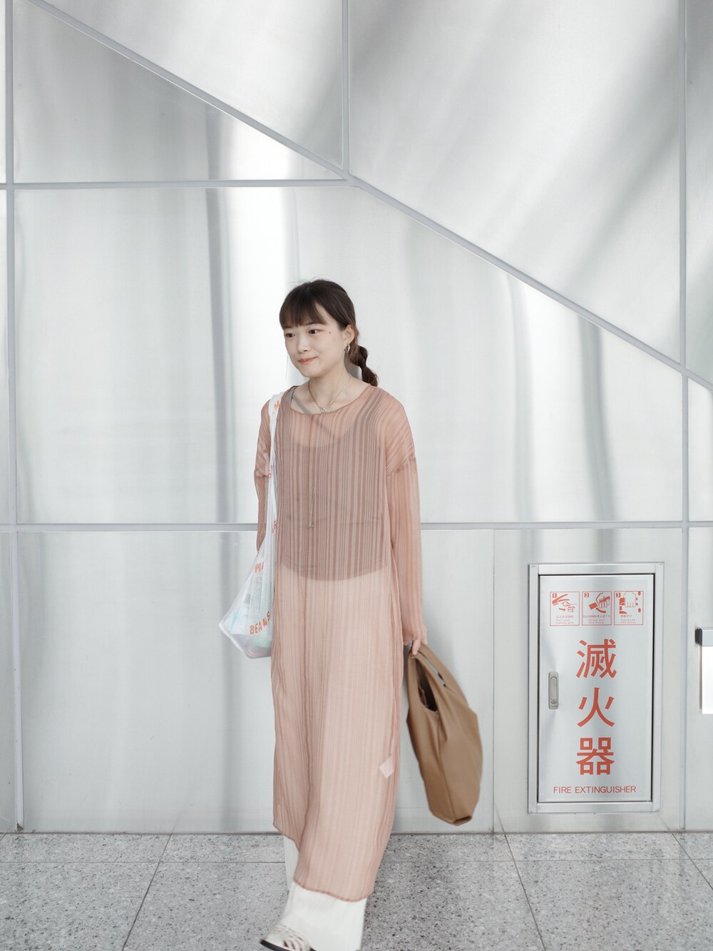 ブラウン系のトートバッグ、ホワイト系のタンクトップ、ピンク系のワンピースを着用したレディースの夏コーディネートの5枚目の写真