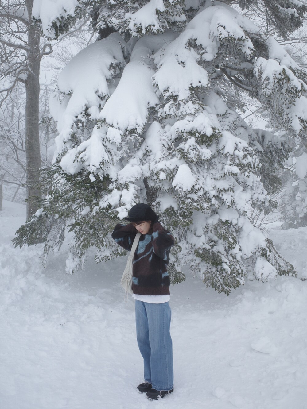 ブラウン系のニット/セーター、ブルー系のデニムパンツ、ブラック系のブーツを着用したレディースの冬コーディネートの3枚目の写真