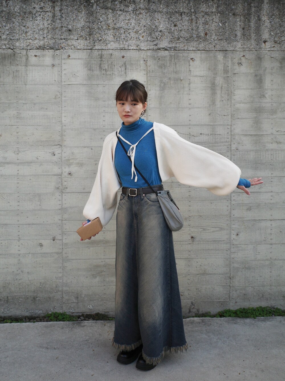 ホワイト系のカーディガン/ボレロ、グレー系のショルダーバッグ、ブラック系のブーツを着用したレディースの冬コーディネートの2枚目の写真