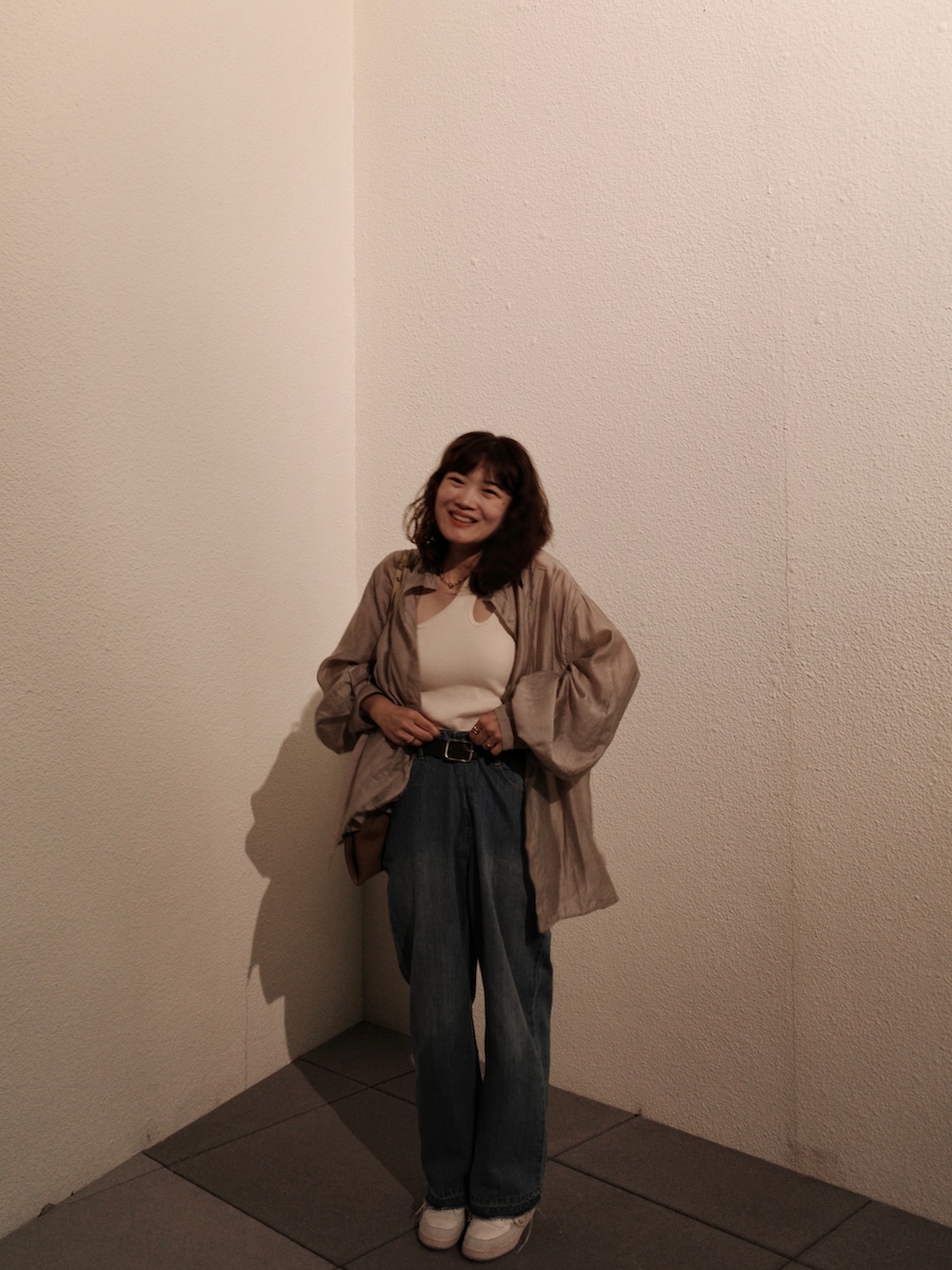 ブルー系のシャツ/ブラウス、ベージュ系のタンクトップ、ブラウン系のトートバッグを着用したレディースの秋コーディネートの4枚目の写真