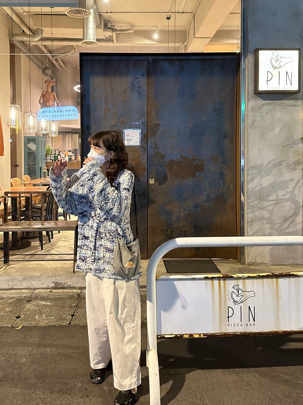 ブルー系のニット/セーター、ホワイト系のパンツ、グレー系のショルダーバッグを着用したレディースの春コーディネートの4枚目の写真