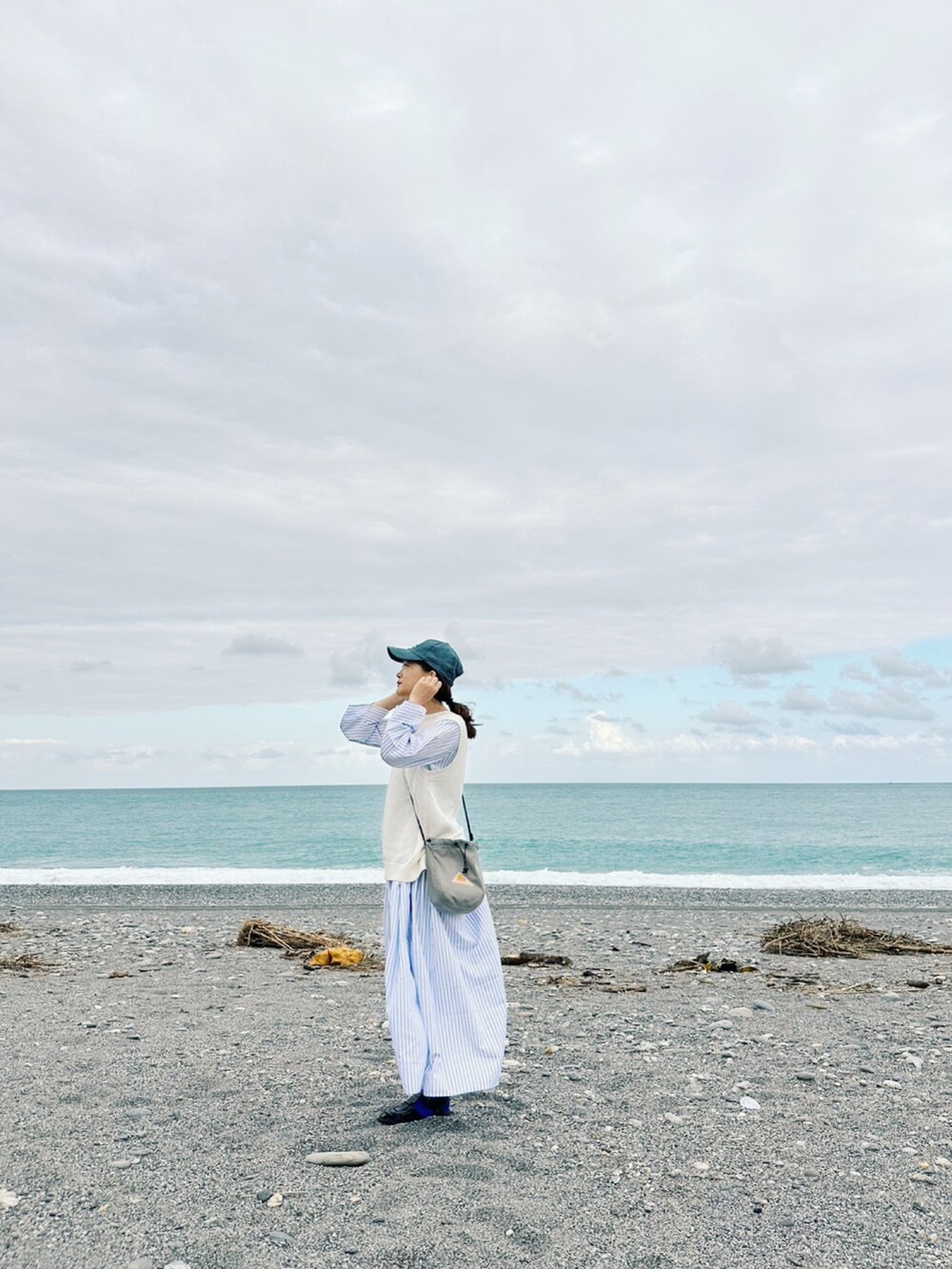 ブルー系のワンピース、グレー系のショルダーバッグ、ブルー系のキャップを着用したレディースの冬コーディネートの3枚目の写真