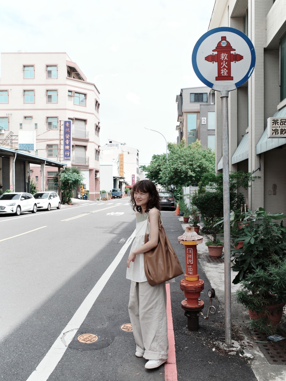 ベージュ系のデニムパンツ、ホワイト系のキャミソール、ブラウン系のトートバッグを着用したレディースの秋コーディネートの2枚目の写真