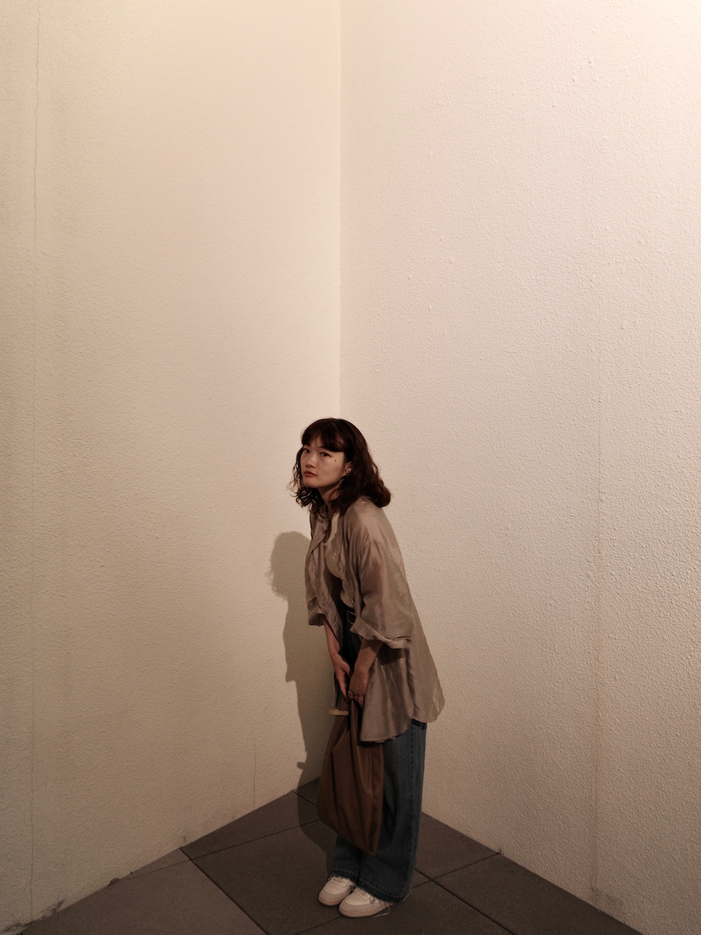 ブルー系のシャツ/ブラウス、ベージュ系のタンクトップ、ブラウン系のトートバッグを着用したレディースの秋コーディネートの3枚目の写真