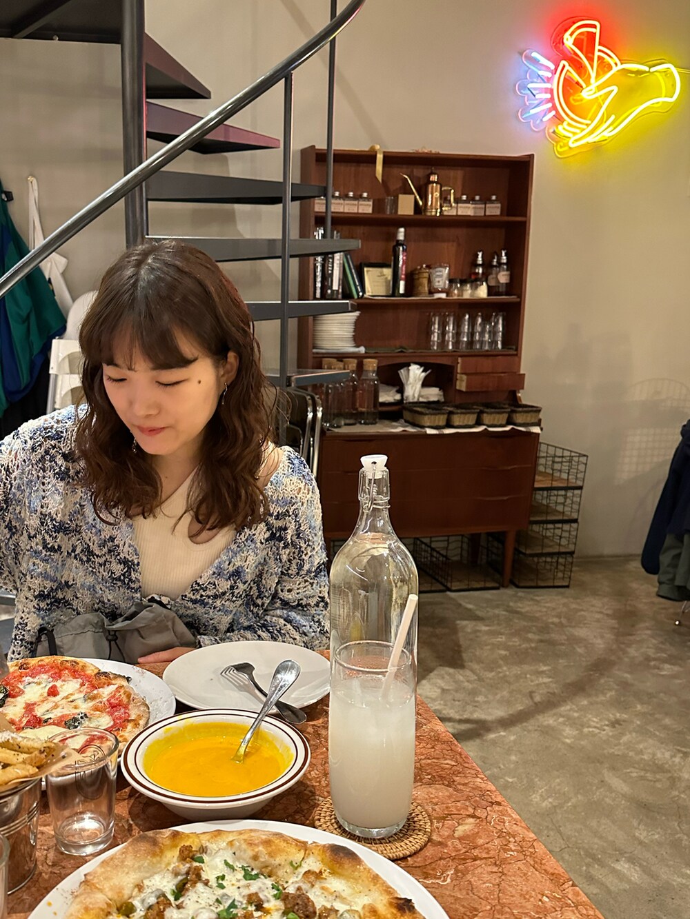 ブルー系のニット/セーター、ホワイト系のパンツ、グレー系のショルダーバッグを着用したレディースの春コーディネートの3枚目の写真