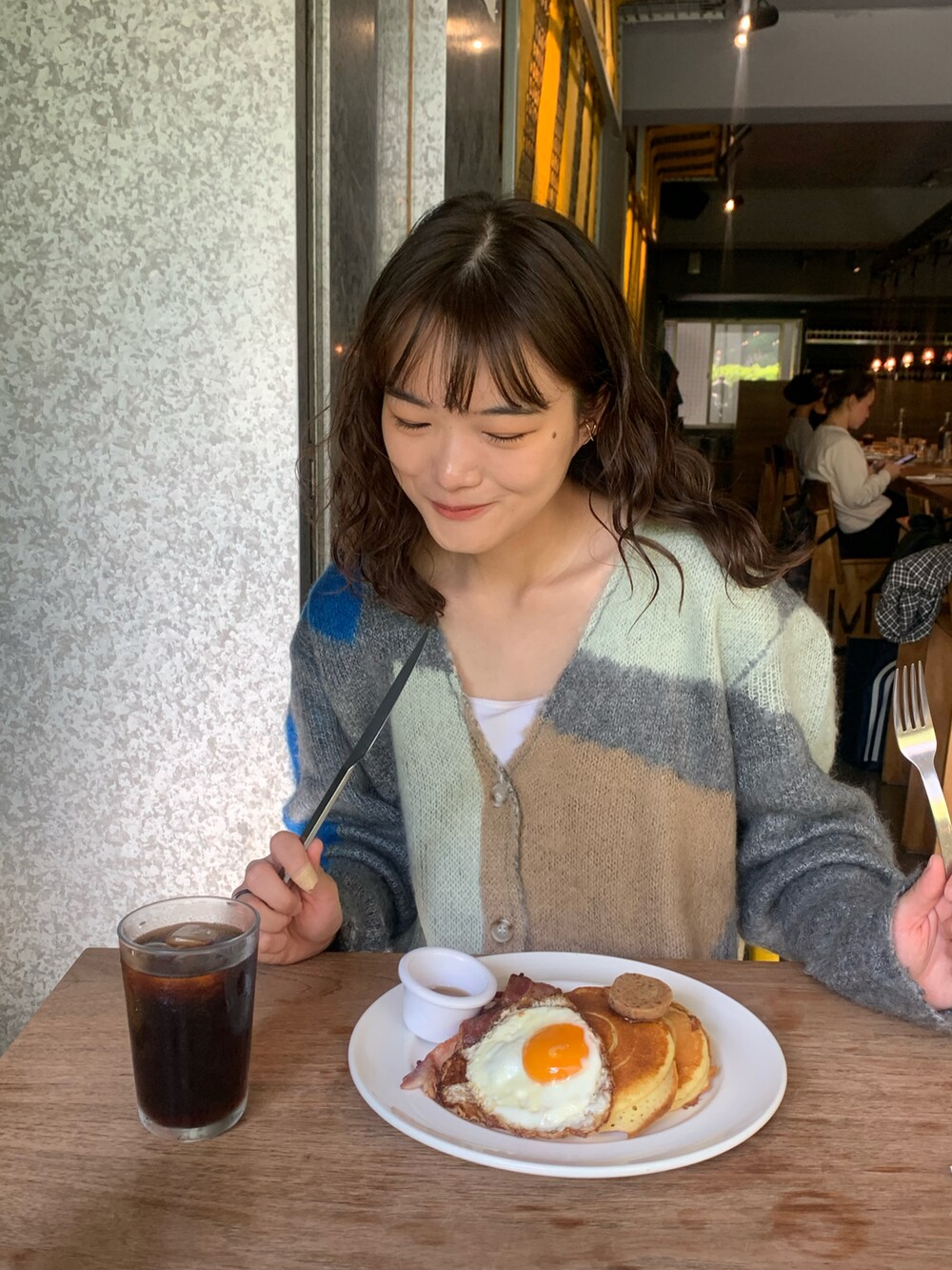 ベージュ系のスニーカー、ブラウン系のパンツ、グレー系のカーディガン/ボレロを着用したレディースの冬コーディネートの4枚目の写真