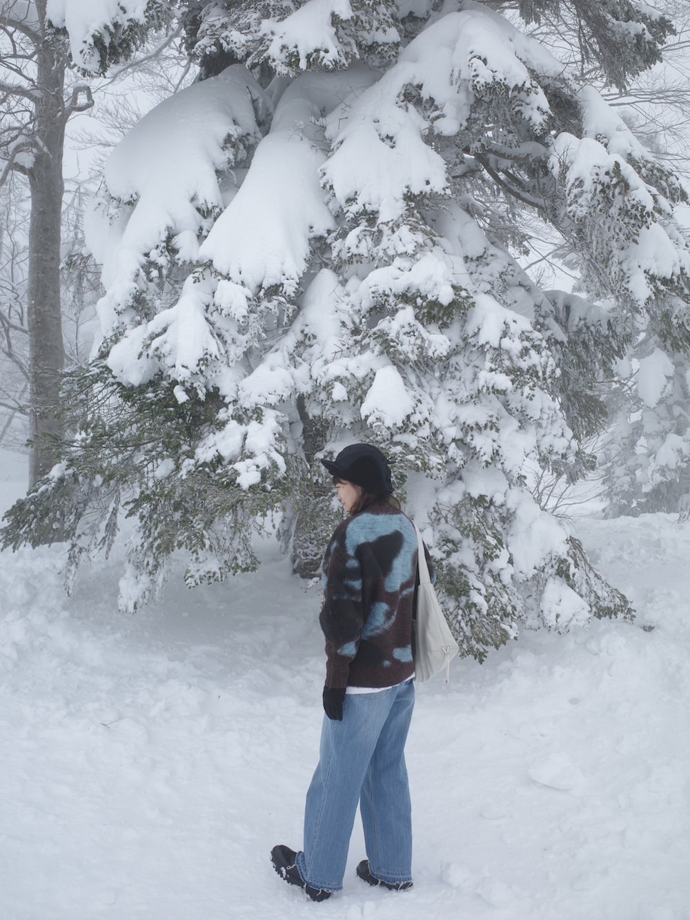 ブラウン系のニット/セーター、ブルー系のデニムパンツ、ブラック系のブーツを着用したレディースの冬コーディネートの2枚目の写真