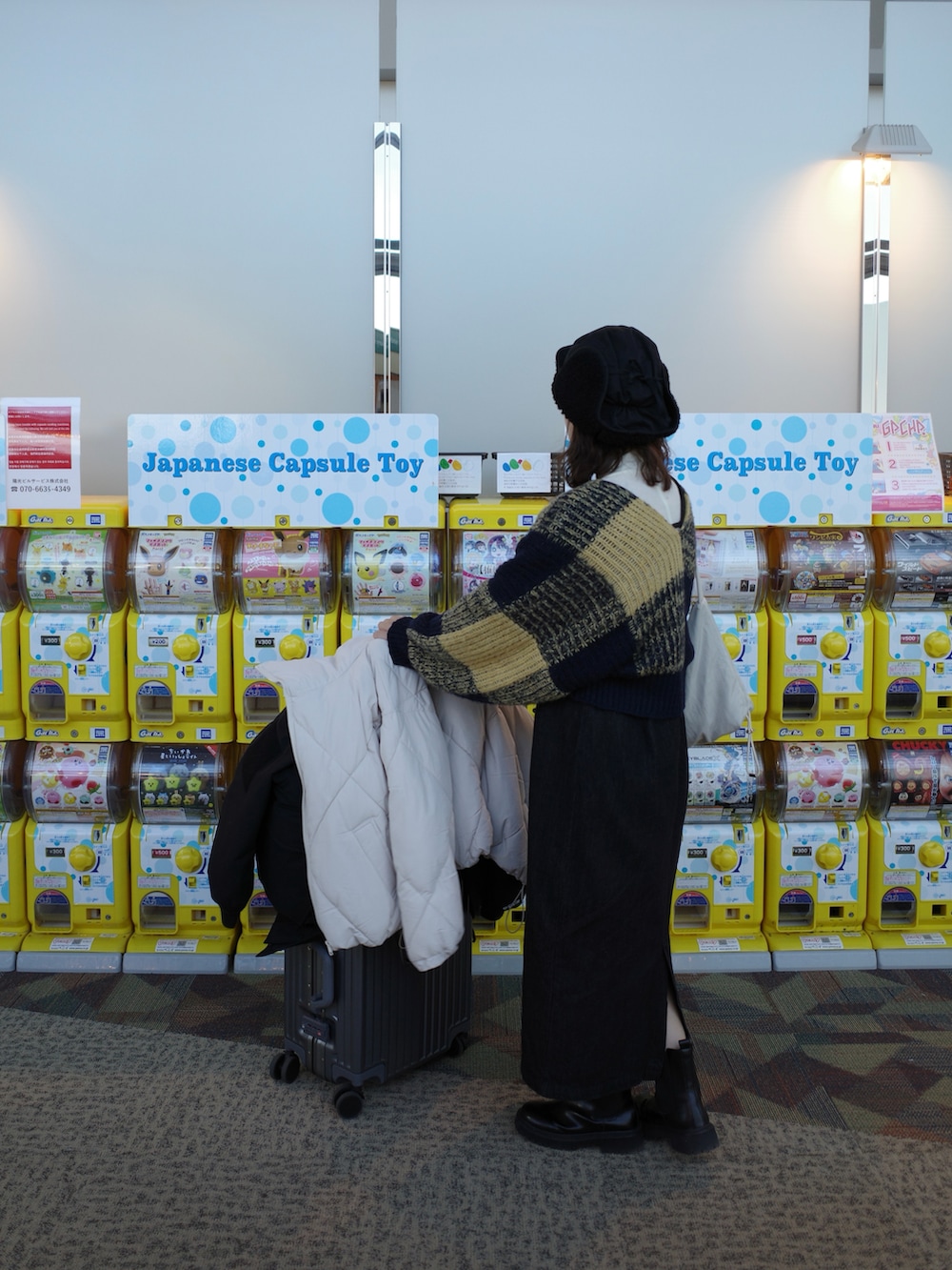 ブルー系のニット/セーター、ブラック系のジャンパースカート、ブラック系のブーツを着用したレディースの冬コーディネートの2枚目の写真