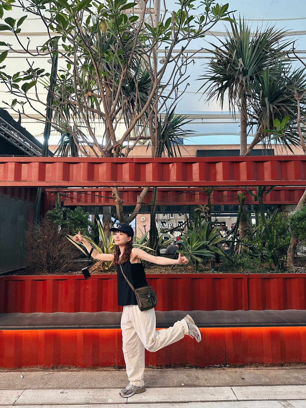 グリーン系のショルダーバッグ、グレー系のスニーカー、ブルー系のキャップを着用したレディースの夏コーディネートの4枚目の写真