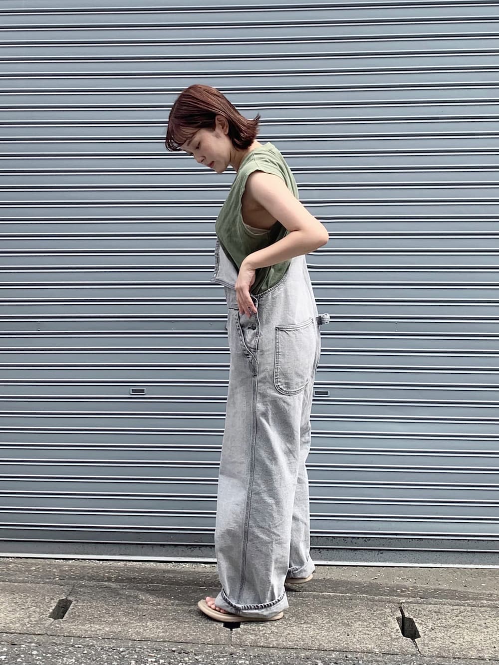 グレー系のサロペット/オーバーオール、グリーン系のTシャツ/カットソー、ベージュ系のサンダルを着用したレディースの夏コーディネートの4枚目の写真