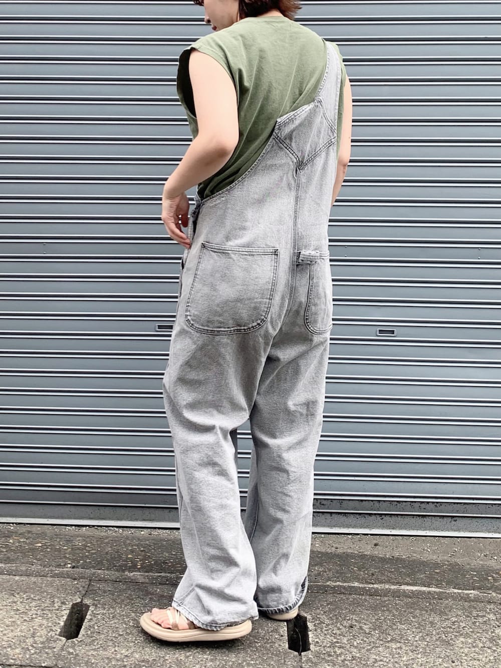 グレー系のサロペット/オーバーオール、グリーン系のTシャツ/カットソー、ベージュ系のサンダルを着用したレディースの夏コーディネートの3枚目の写真