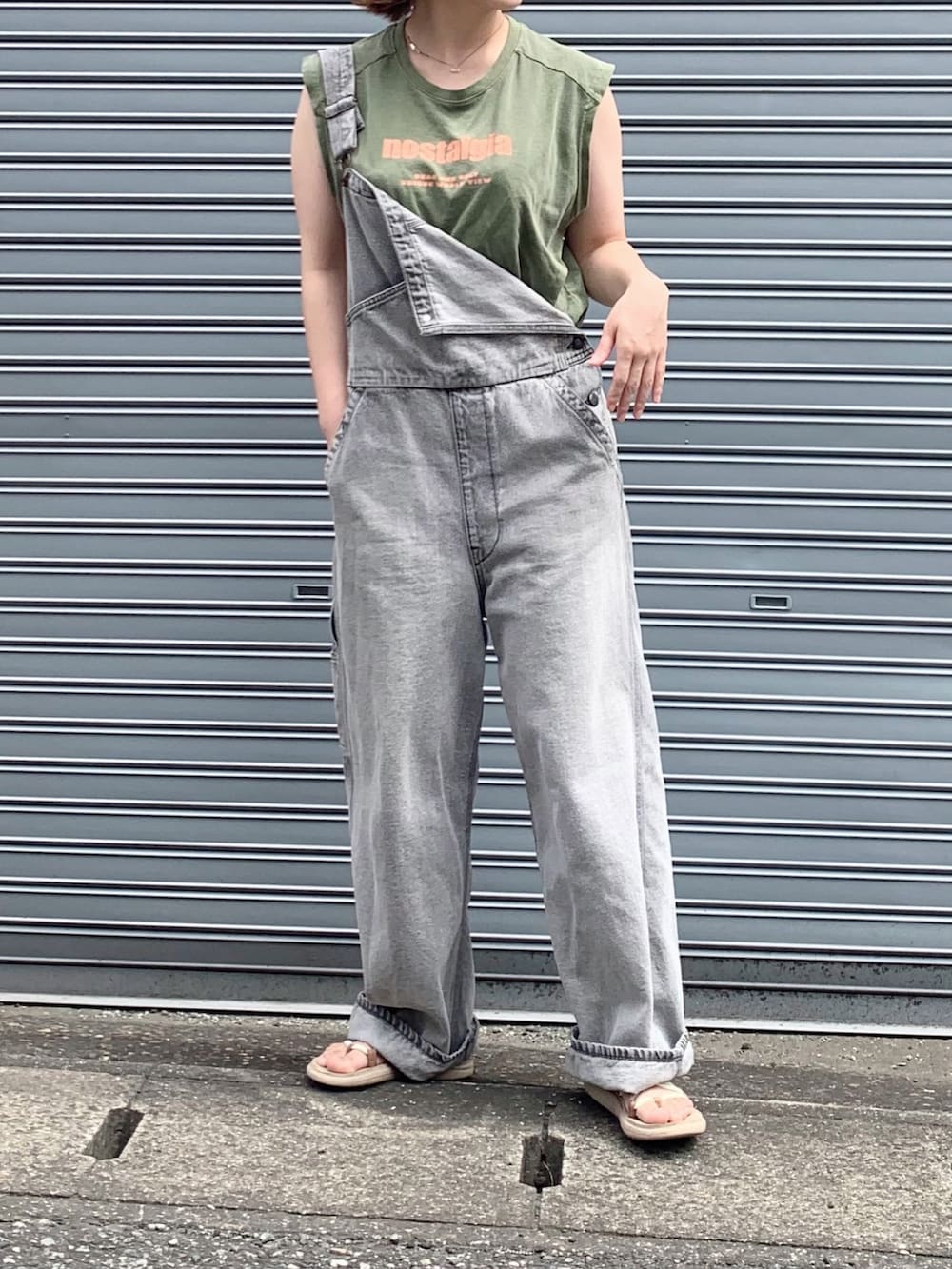 グレー系のサロペット/オーバーオール、グリーン系のTシャツ/カットソー、ベージュ系のサンダルを着用したレディースの夏コーディネートの2枚目の写真
