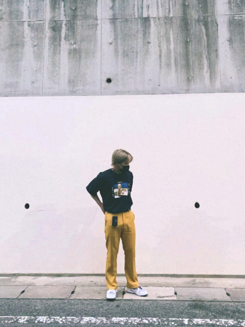 イエロー系のスラックス、ホワイト系のスニーカー、ブラック系のTシャツ/カットソーを着用したメンズの春コーディネートの3枚目の写真