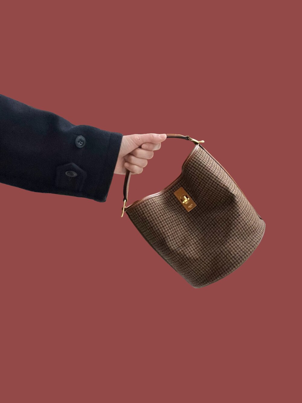 ブルー系のチェスターコート、ブラウン系のドラムバッグ、ブラック系のサンダルを着用したレディースの春コーディネートの2枚目の写真