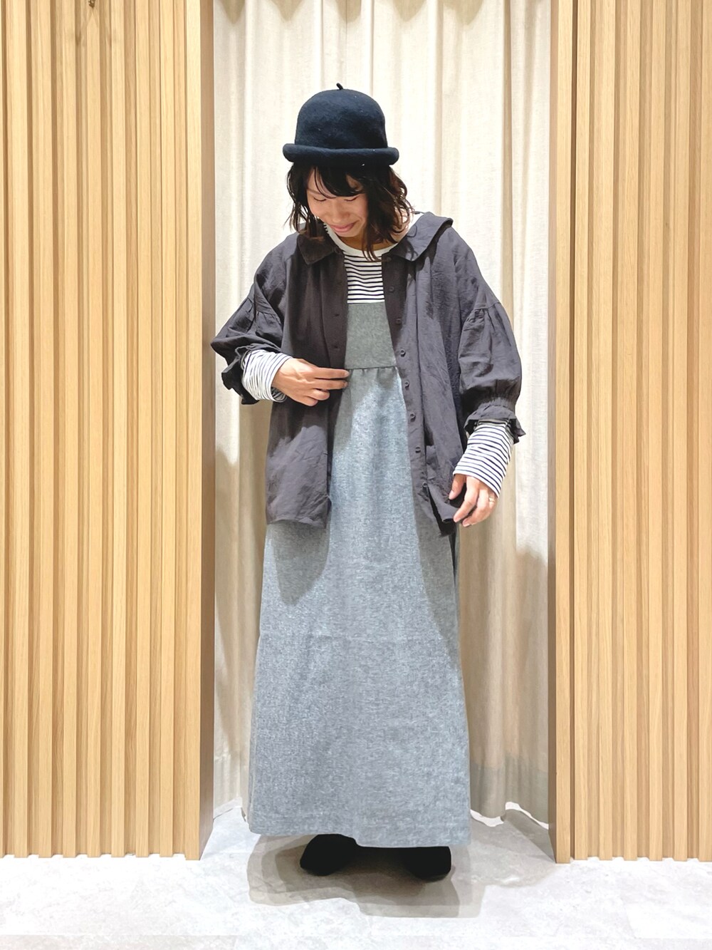 グレー系のワンピース、グレー系のシャツ/ブラウス、ブラック系のハットを着用したレディースの秋コーディネートの2枚目の写真