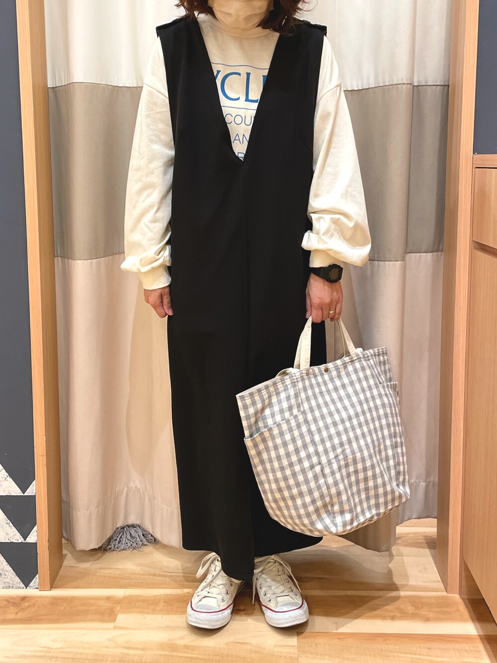 ホワイト系のTシャツ/カットソー、ブラック系のワンピース、ホワイト系のスニーカーを着用したレディースの冬コーディネートの2枚目の写真